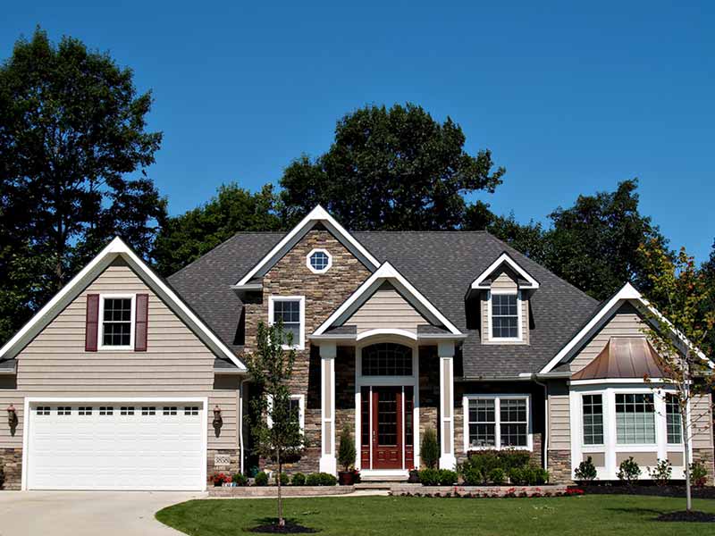 Front view of a higher-end, mid-class home with a gray shingle roof